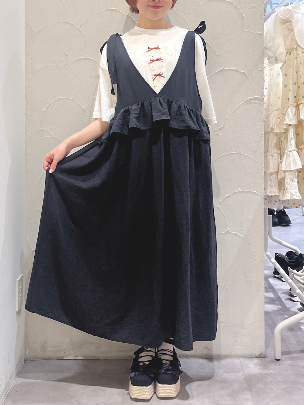 ブラック系のワンピース、ホワイト系のTシャツ/カットソー、ブラック系のサンダルを着用したレディースの春コーディネートの2枚目の写真