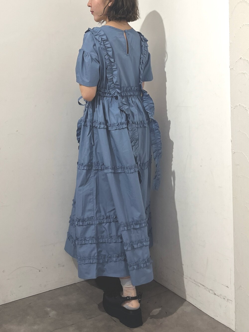 ホワイト系のトートバッグ、ブルー系のワンピース、ブラック系のサンダルを着用したレディースの夏コーディネートの5枚目の写真