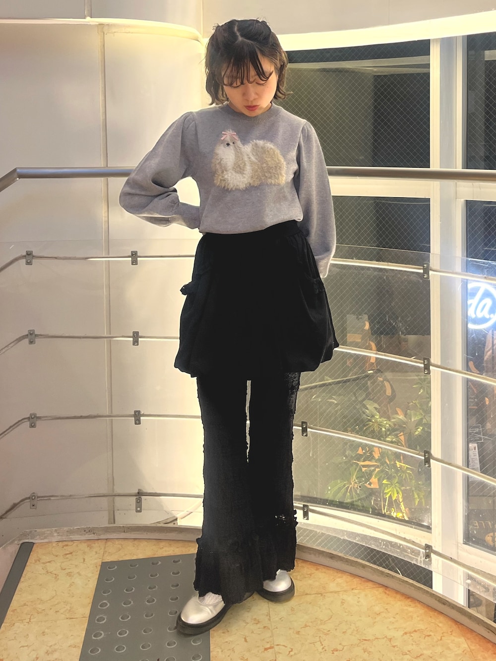 グレー系のニット/セーター、ブラック系のMA-1、ブラック系のスカートを着用したレディースの秋コーディネートの5枚目の写真