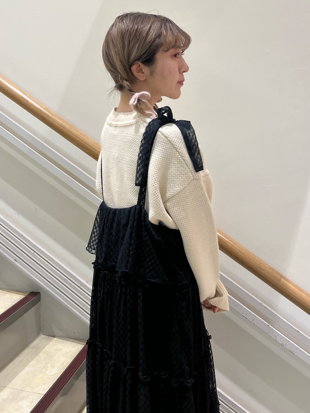 ブラック系のワンピース、ホワイト系のニット/セーター、ブラック系のパンプスを着用したレディースの冬コーディネートの6枚目の写真