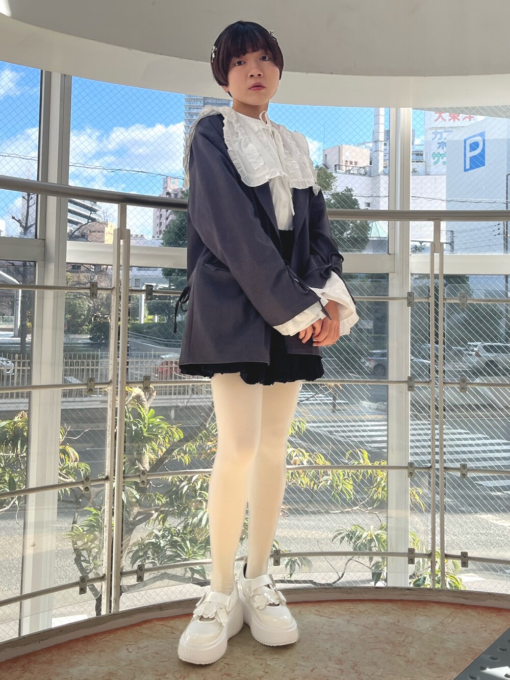 グレー系のテーラードジャケット、ホワイト系のシャツ/ブラウス、ブラック系のスカートを着用したレディースの冬コーディネートの3枚目の写真