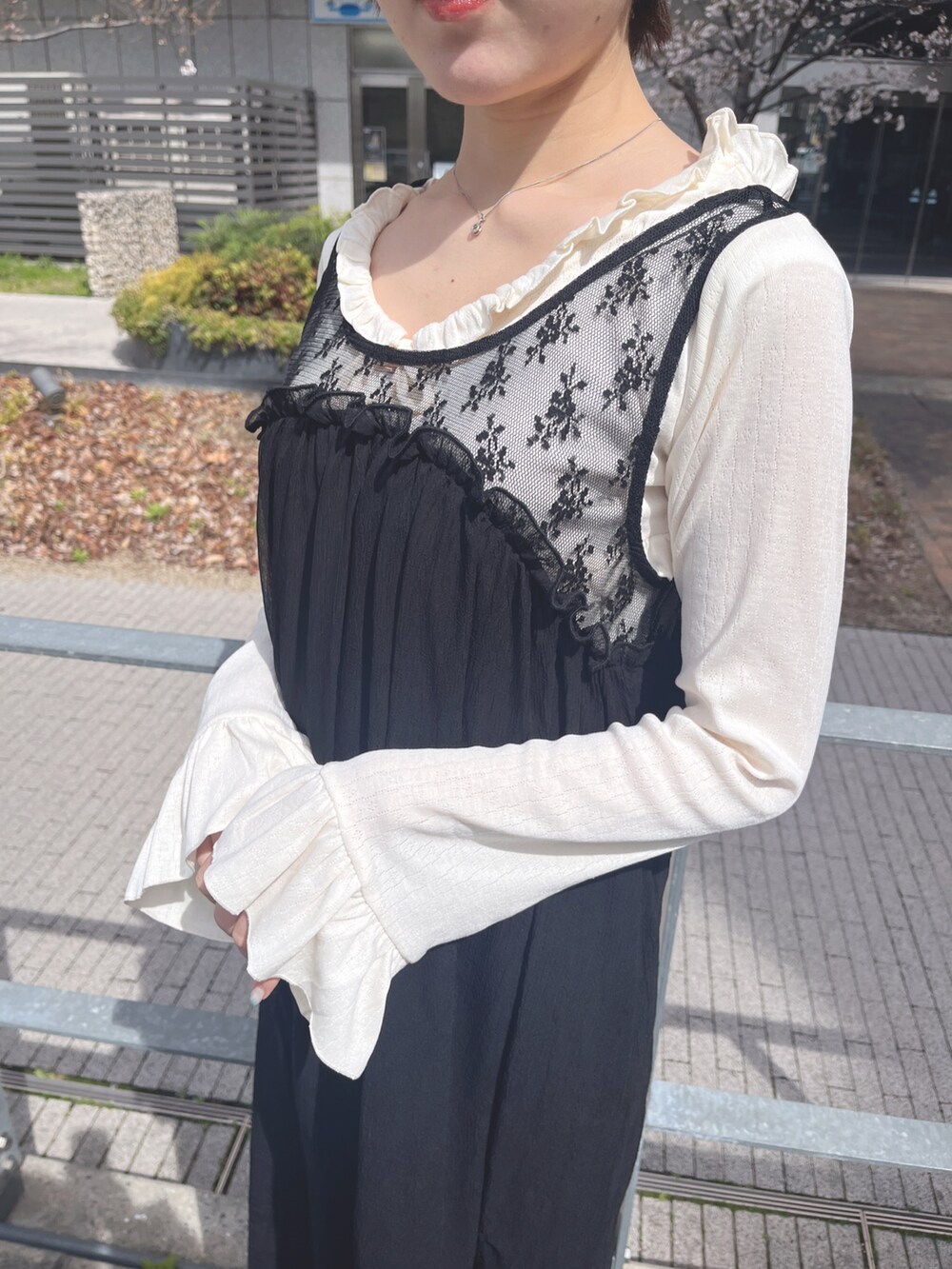 ホワイト系のTシャツ/カットソー、ブラック系のワンピース、ブラック系のスニーカーを着用したレディースの春コーディネートの7枚目の写真