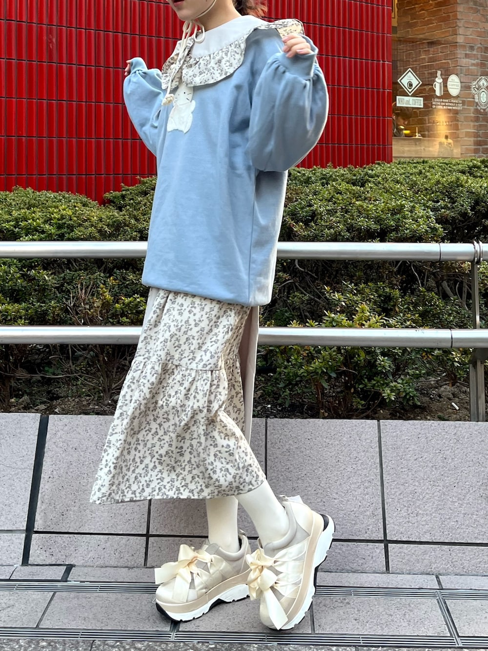 ブルー系のスウェット、ブルー系のワンピース、ホワイト系のスニーカーを着用したレディースの冬コーディネートの3枚目の写真