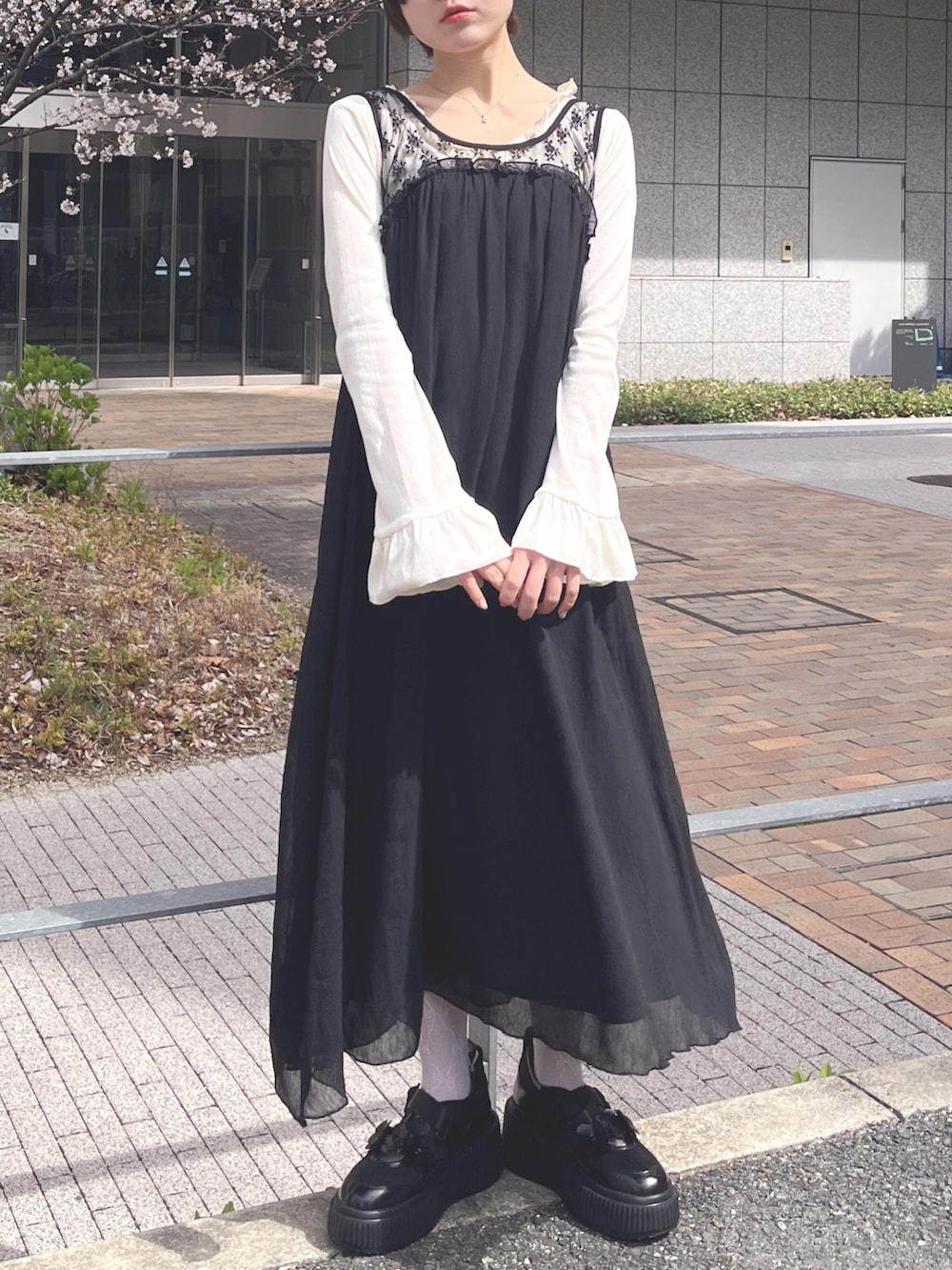 ホワイト系のTシャツ/カットソー、ブラック系のワンピース、ブラック系のスニーカーを着用したレディースの春コーディネートの2枚目の写真