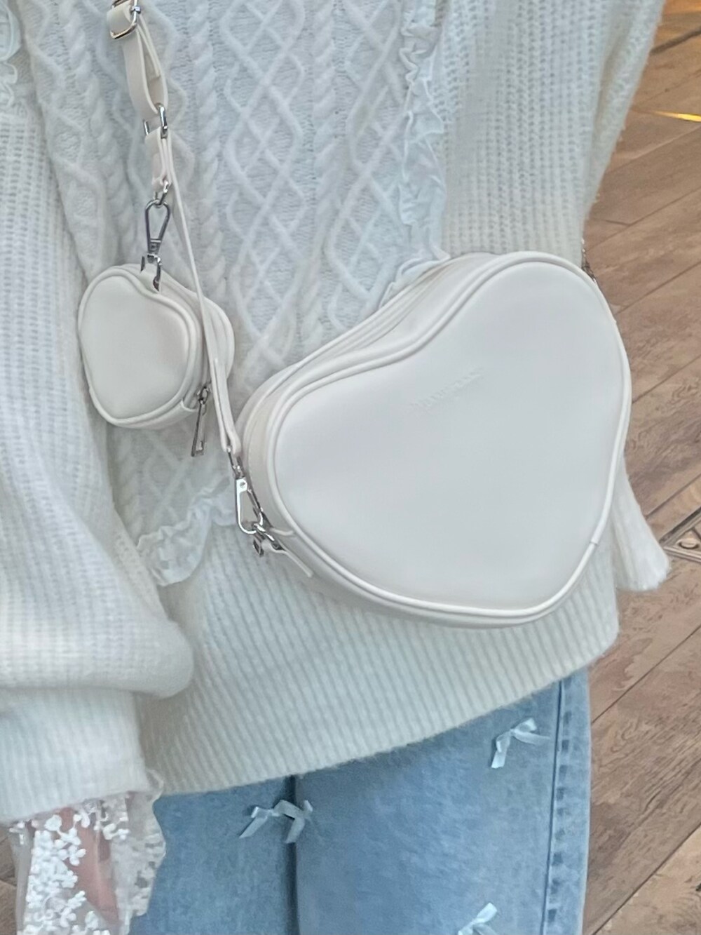 ホワイト系のショルダーバッグ、ホワイト系のニット/セーター、ブルー系のシャツ/ブラウスを着用したレディースの冬コーディネートの6枚目の写真