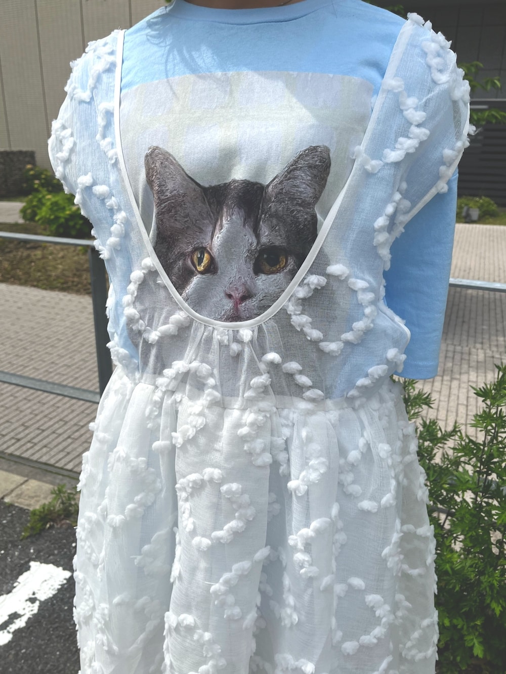 ホワイト系のジャンパースカート、ブルー系のTシャツ/カットソー、ブルー系のデニムパンツを着用したレディースの春コーディネートの8枚目の写真