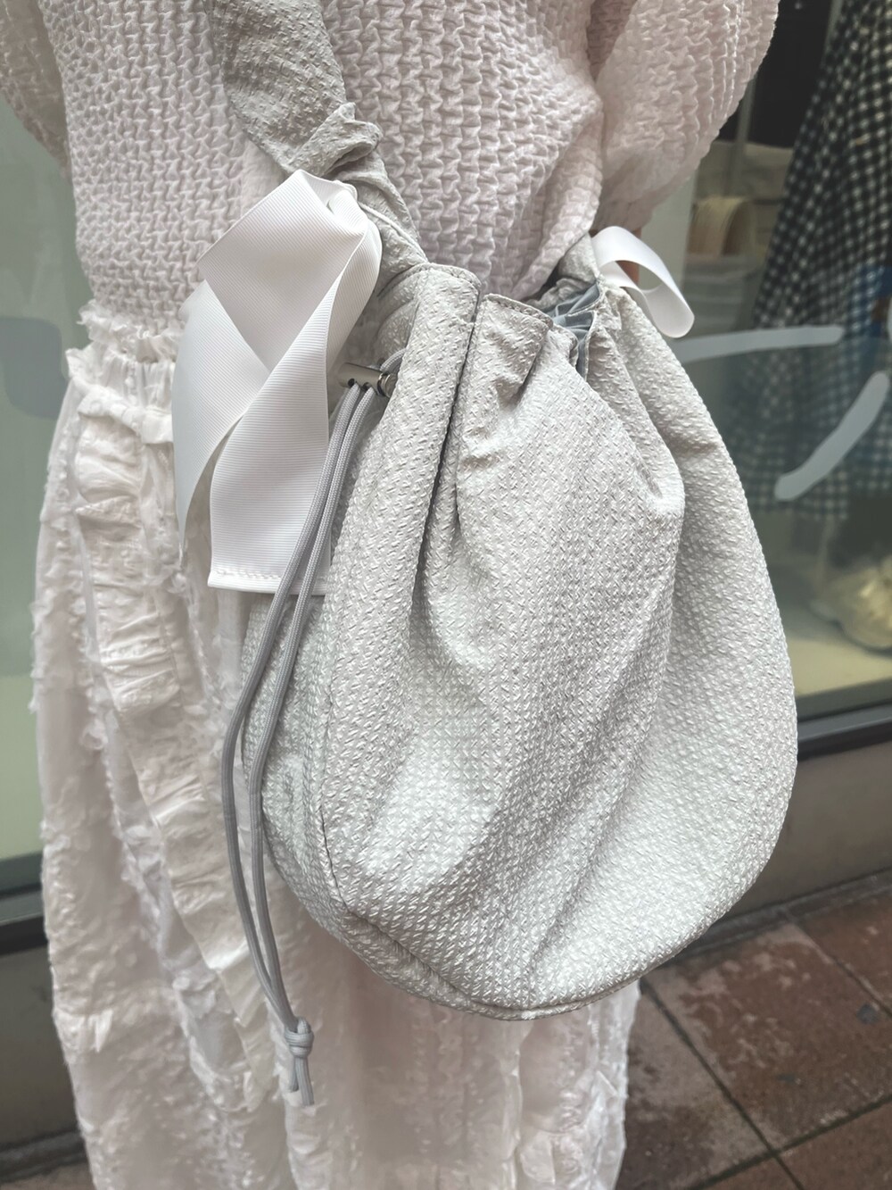 ホワイト系のスカート、ホワイト系のシャツ/ブラウス、グリーン系のショルダーバッグを着用したレディースの夏コーディネートの8枚目の写真