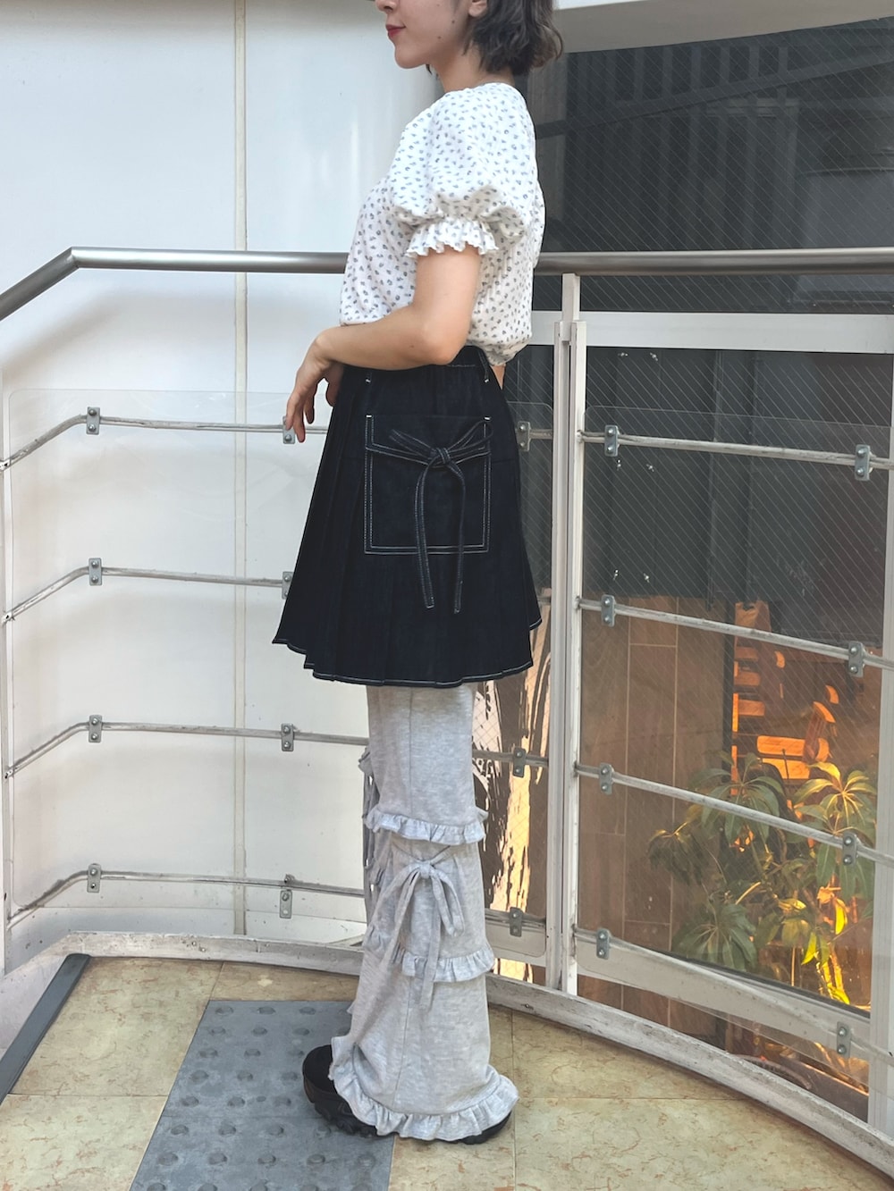 ブラック系のスカート、グレー系のスウェットパンツ、ブラック系のスニーカーを着用したレディースの夏コーディネートの4枚目の写真