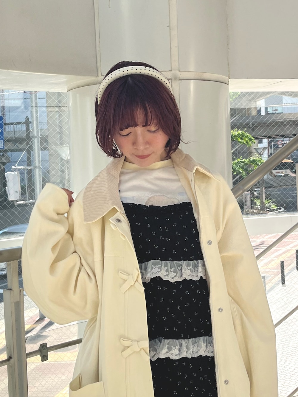 ブラック系のチュニック、イエロー系のTシャツ/カットソー、ホワイト系のブルゾンを着用したレディースの秋コーディネートの9枚目の写真