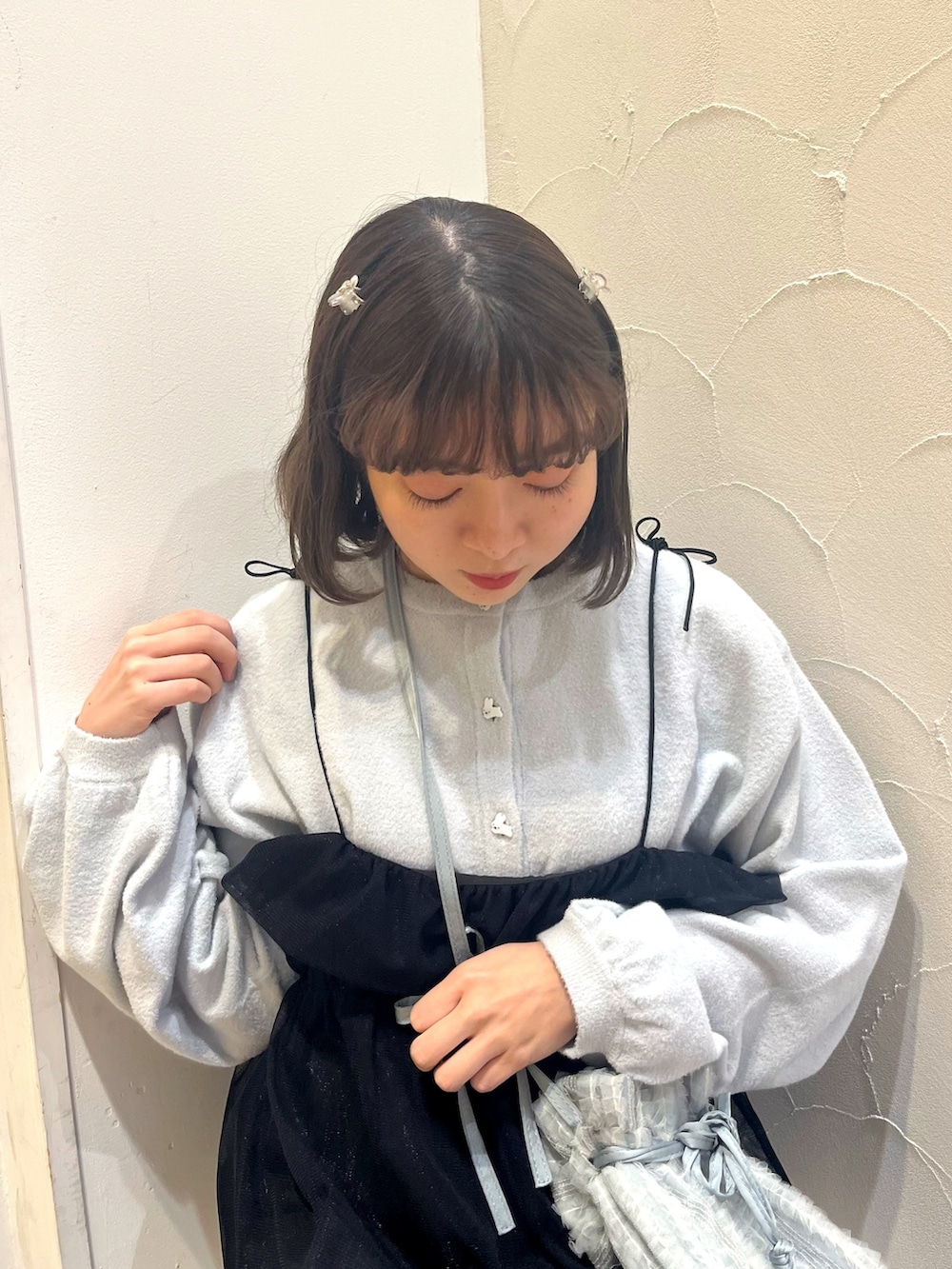 ブラック系のワンピース、ブルー系のショルダーバッグ、ホワイト系のパンプスを着用したレディースの春コーディネートの7枚目の写真