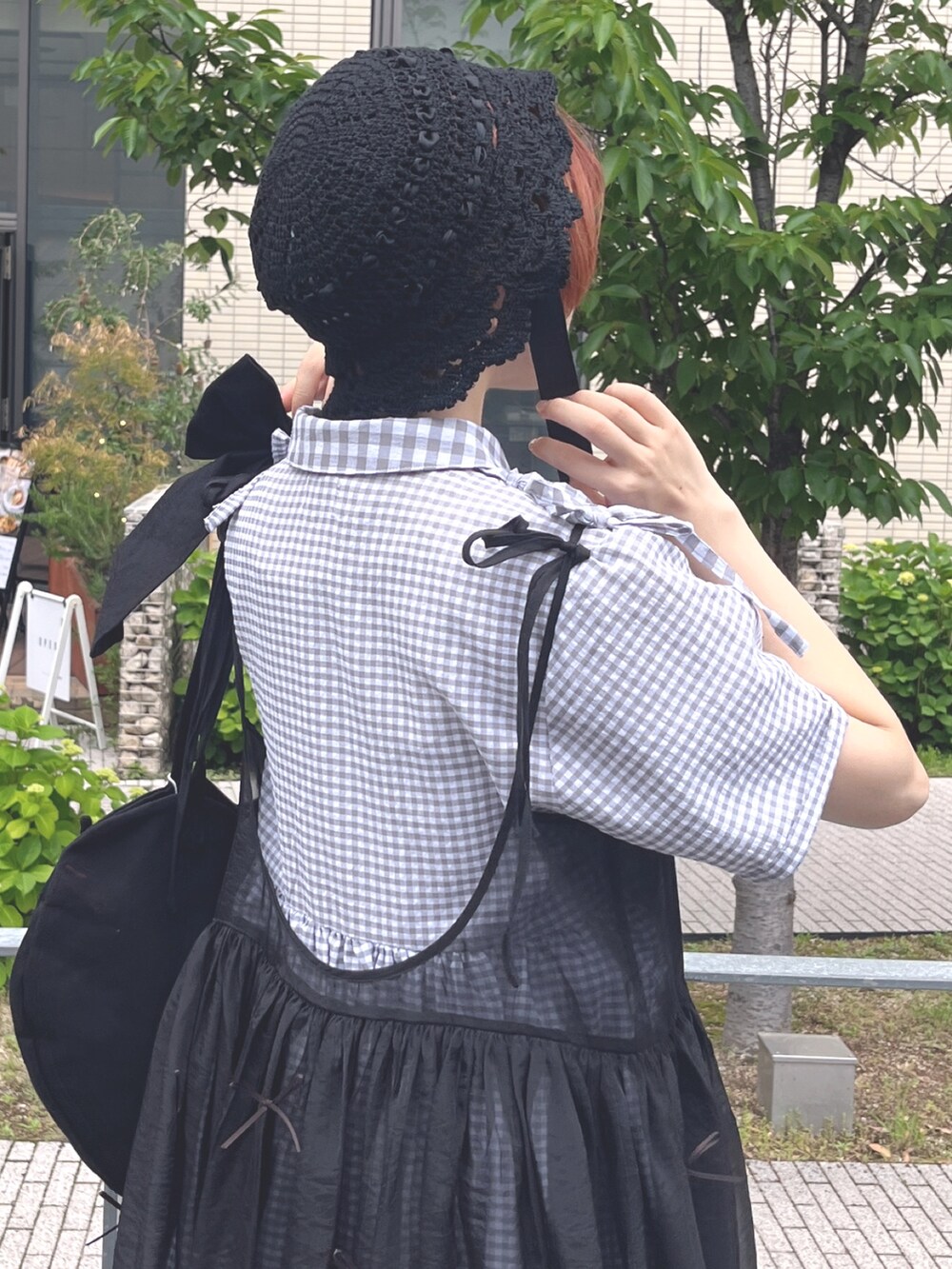 ブラック系のサンダル、ブラック系のトートバッグ、ブラック系のワンピースを着用したレディースの春コーディネートの7枚目の写真