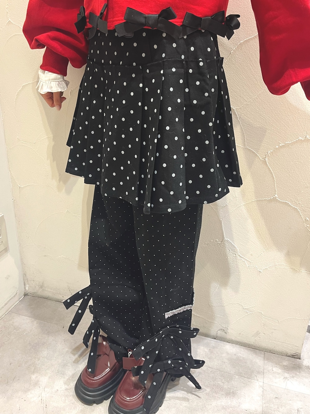 ブラック系のスカート、ブラック系のスラックス、レッド系のローファーを着用したレディースの秋コーディネートの8枚目の写真