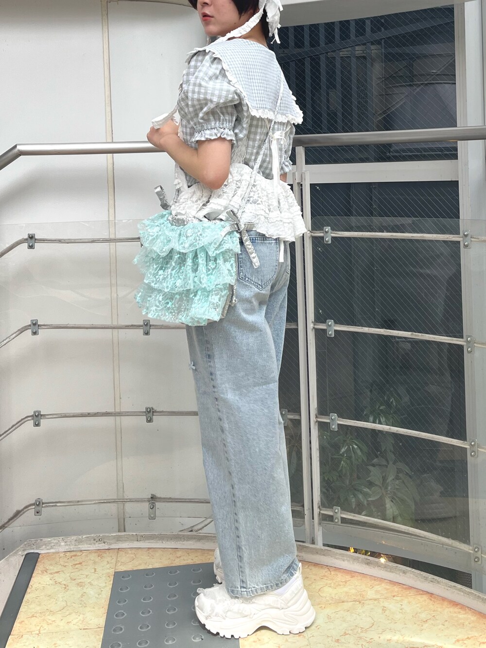 ホワイト系のキャミソール、グリーン系のシャツ/ブラウス、ブルー系のショルダーバッグを着用したレディースの春コーディネートの2枚目の写真