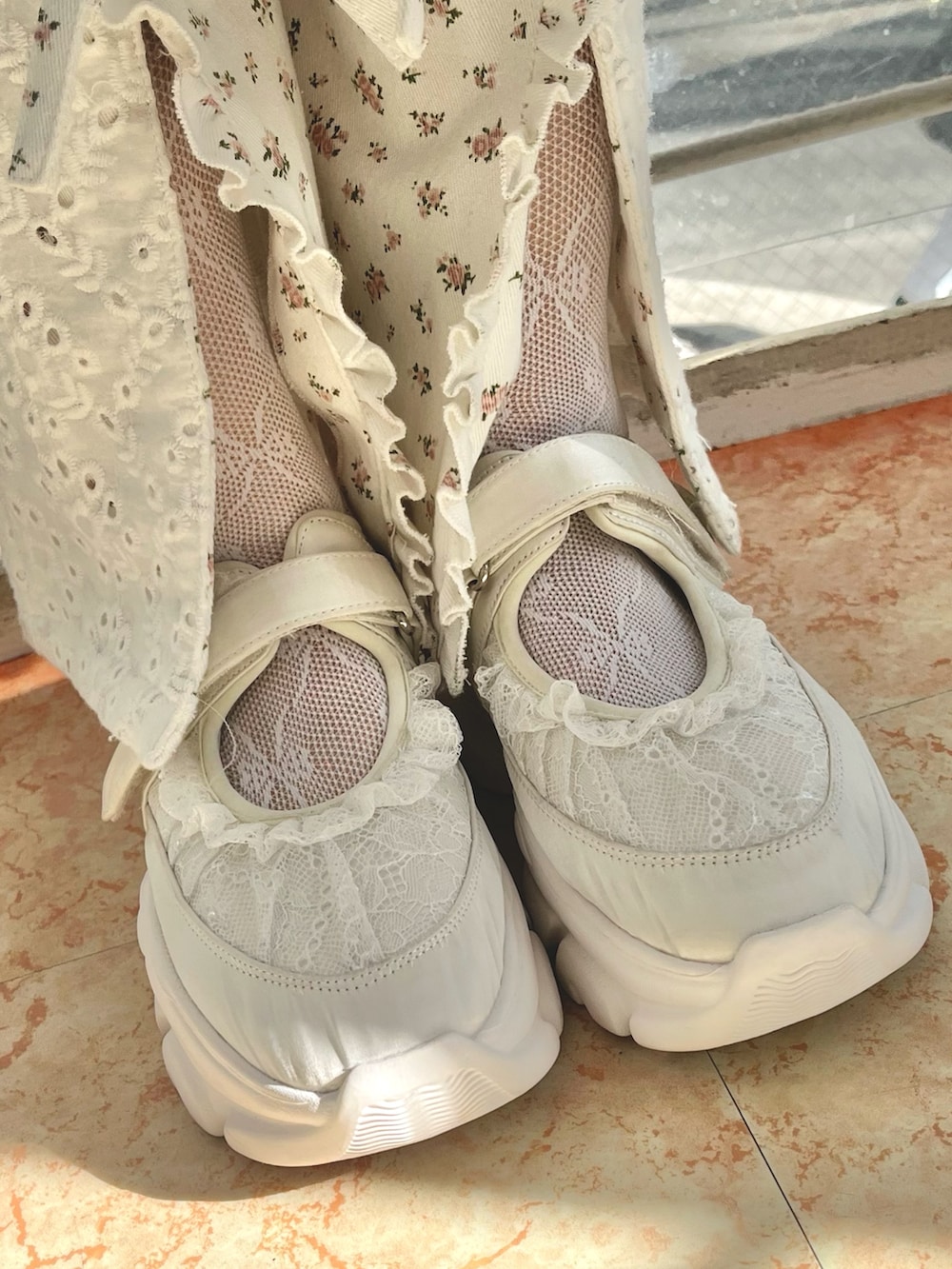 ホワイト系のスウェット、ホワイト系のカーディガン/ボレロ、ホワイト系のスカートを着用したレディースの冬コーディネートの9枚目の写真