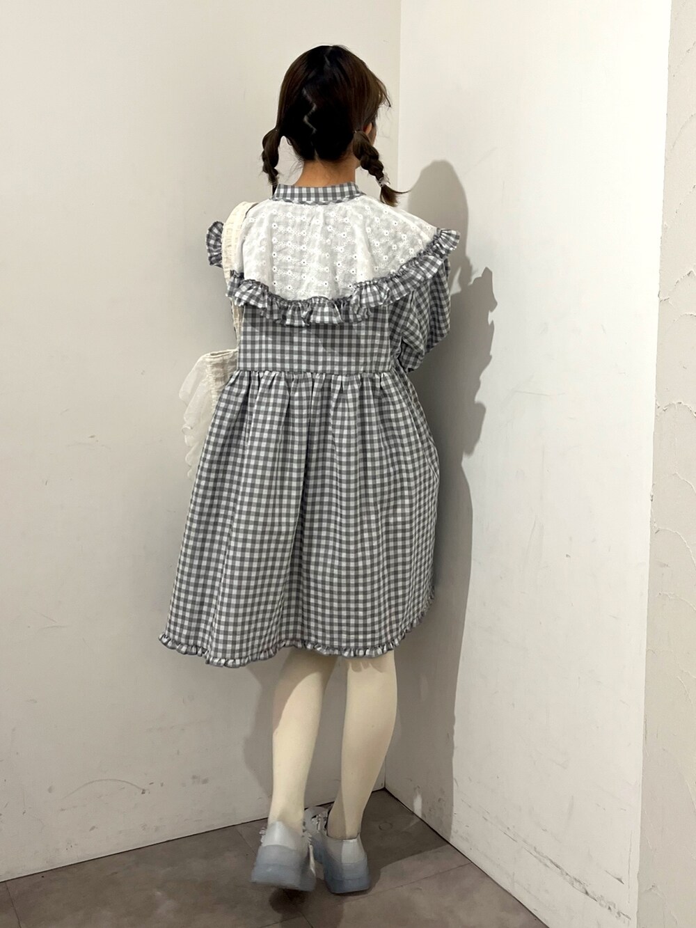 グレー系のワンピース、ホワイト系のトートバッグ、ブルー系のスニーカーを着用したレディースの春コーディネートの3枚目の写真