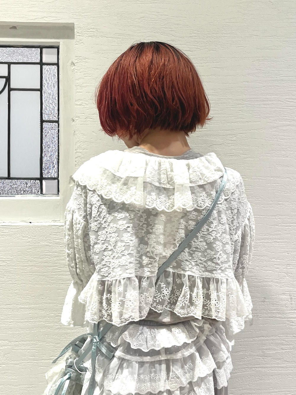 ブルー系のショルダーバッグ、グレー系のTシャツ/カットソー、ホワイト系のカーディガン/ボレロを着用したレディースの秋コーディネートの8枚目の写真