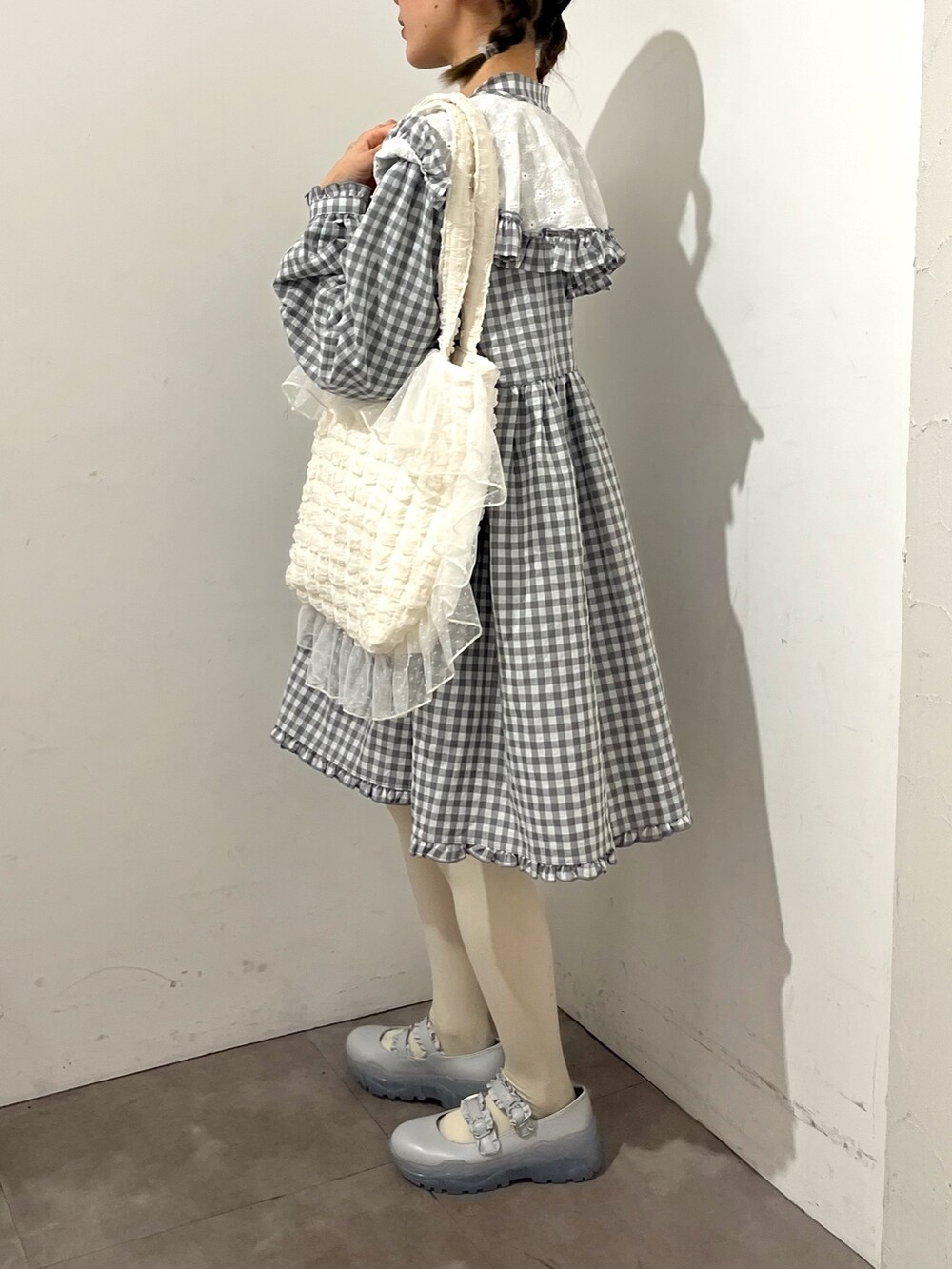 グレー系のワンピース、ホワイト系のトートバッグ、ブルー系のスニーカーを着用したレディースの春コーディネートの2枚目の写真