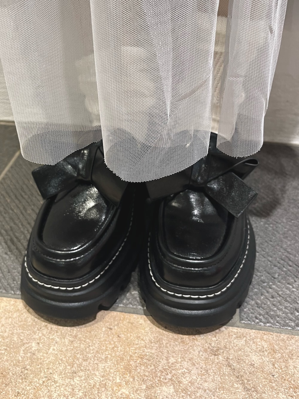 グレー系のパーカー、ブルー系のワンピース、ブラック系のローファーを着用したレディースの秋コーディネートの10枚目の写真