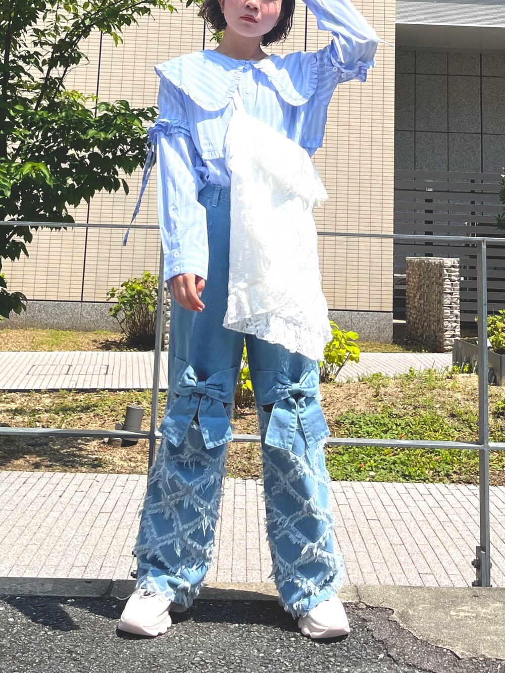 ブルー系のシャツ/ブラウス、ホワイト系のトートバッグ、ブルー系のデニムパンツを着用したレディースの夏コーディネートの2枚目の写真