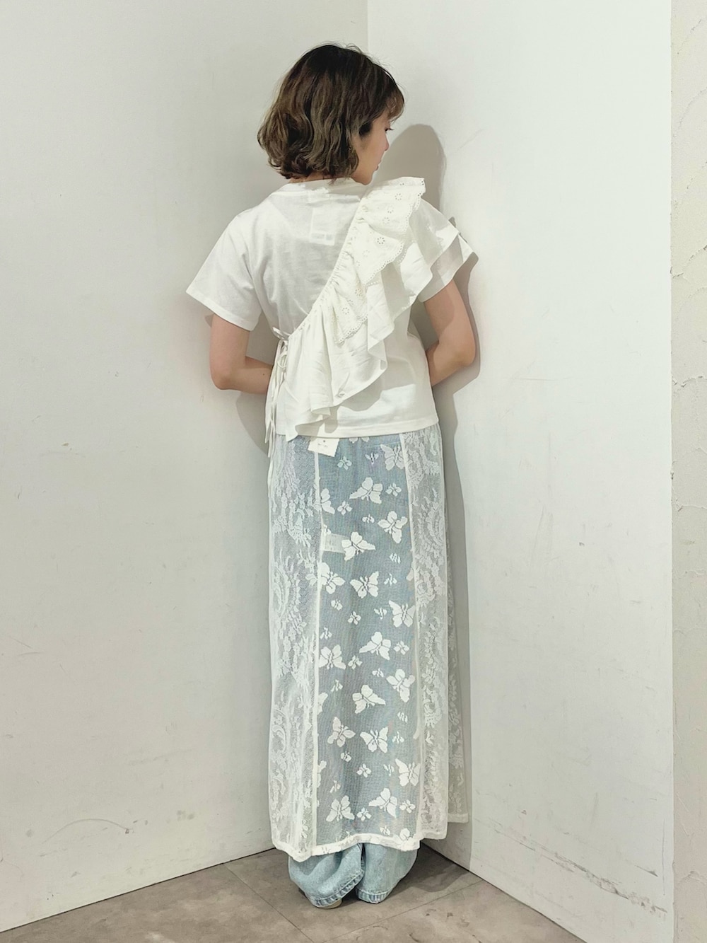 ホワイト系のスカート、ホワイト系のTシャツ/カットソー、ブルー系のデニムパンツを着用したレディースの春コーディネートの4枚目の写真