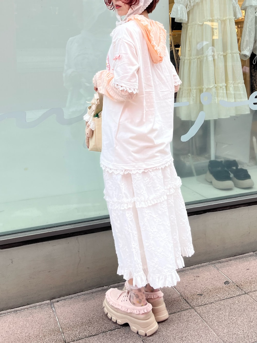 ホワイト系のスカート、ホワイト系のハンドバッグ、ホワイト系のTシャツ/カットソーを着用したレディースの夏コーディネートの3枚目の写真