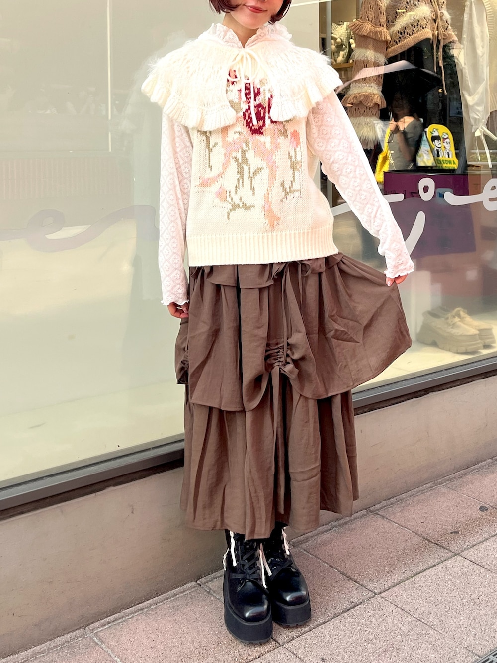 ホワイト系のベスト、ホワイト系のTシャツ/カットソー、ブラウン系のスカートを着用したレディースの秋コーディネートの2枚目の写真