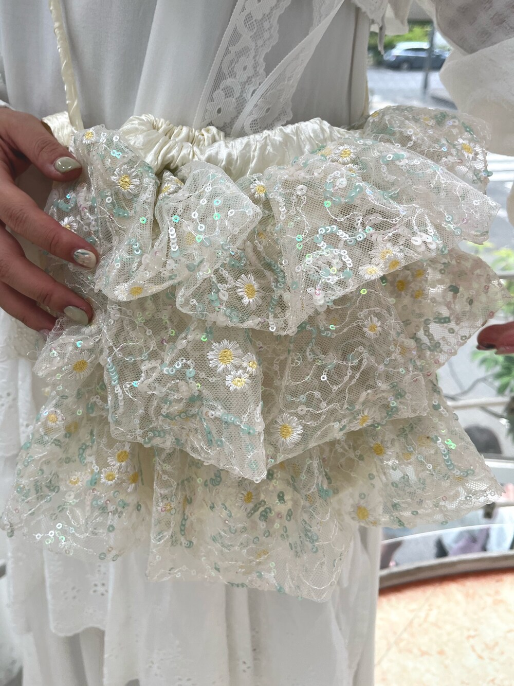 ブラック系のスニーカー、ブラック系のニット/セーター、ホワイト系のワンピースを着用したレディースの春コーディネートの8枚目の写真