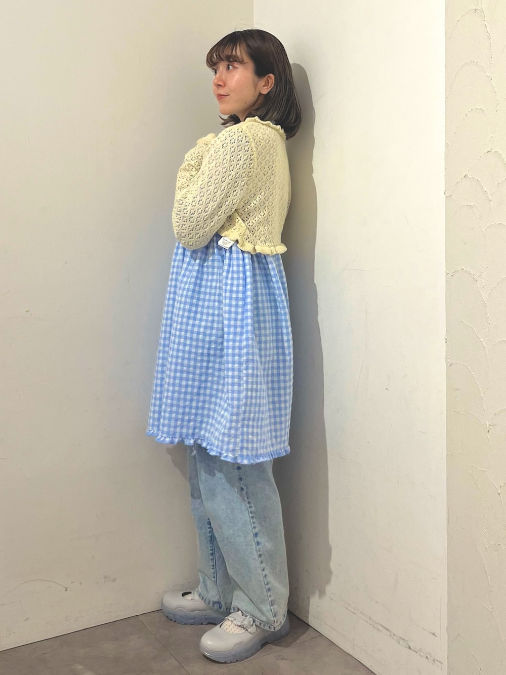 ブルー系のワンピース、ホワイト系のカーディガン/ボレロ、ブルー系のデニムパンツを着用したレディースの春コーディネートの3枚目の写真