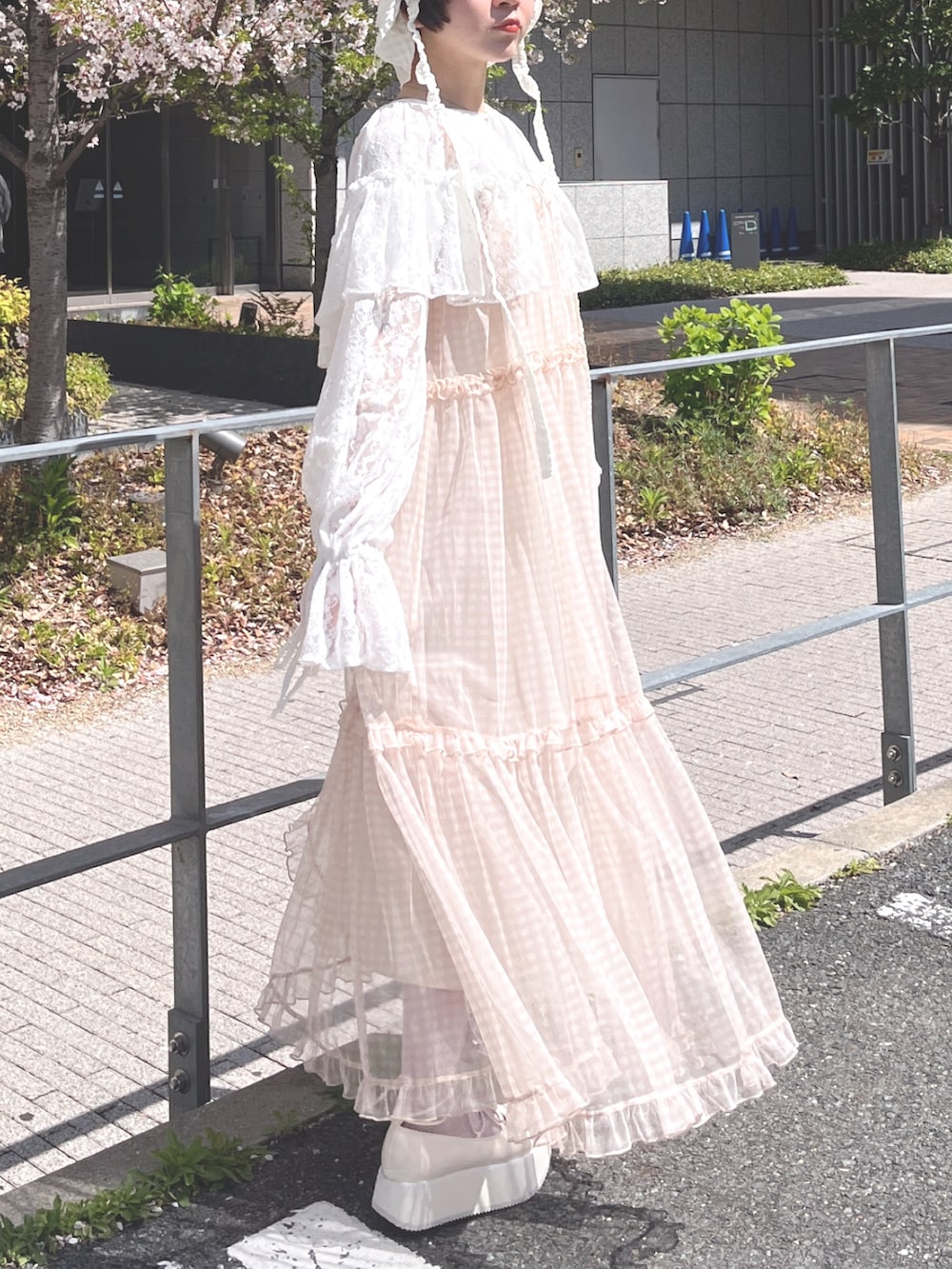 ベージュ系のワンピース、ホワイト系のカーディガン/ボレロ、ホワイト系のTシャツ/カットソーを着用したレディースの春コーディネートの2枚目の写真