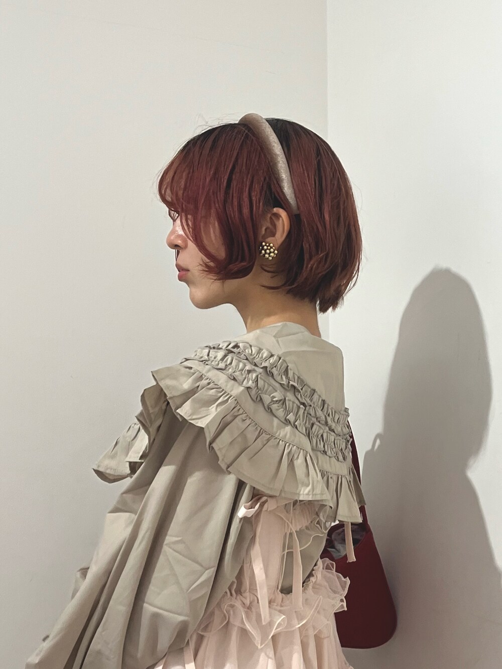 ベージュ系のシャツ/ブラウス、ピンク系のワンピース、レッド系のハンドバッグを着用したレディースの秋コーディネートの7枚目の写真