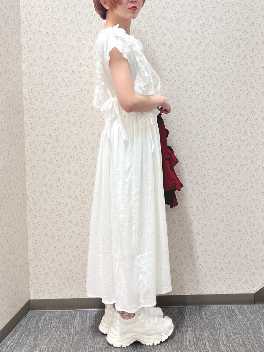 ホワイト系のワンピース、レッド系のトートバッグ、ホワイト系のスニーカーを着用したレディースの春コーディネートの3枚目の写真