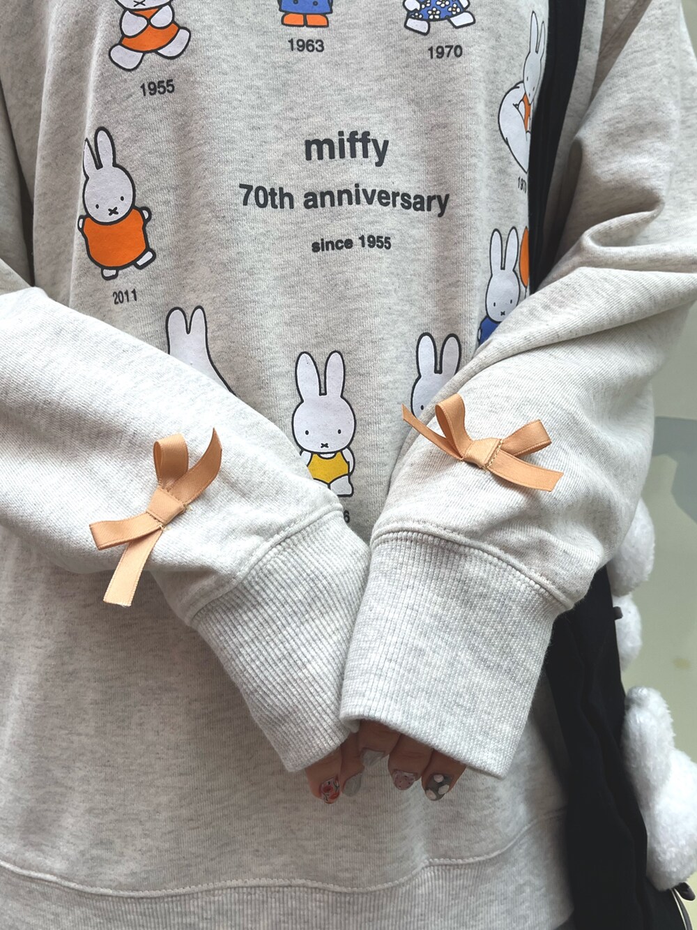 グレー系のスウェット、グレー系のスカート、ブラック系のスニーカーを着用したレディースの冬コーディネートの9枚目の写真