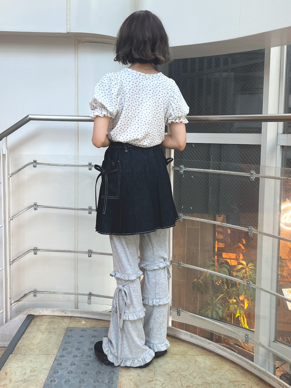 ブラック系のスカート、グレー系のスウェットパンツ、ブラック系のスニーカーを着用したレディースの夏コーディネートの5枚目の写真