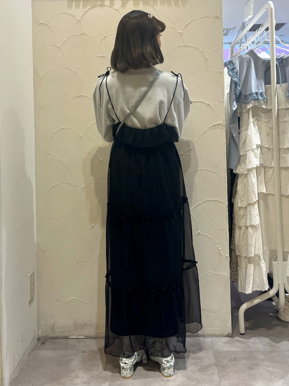 ブラック系のワンピース、ブルー系のショルダーバッグ、ホワイト系のパンプスを着用したレディースの春コーディネートの4枚目の写真