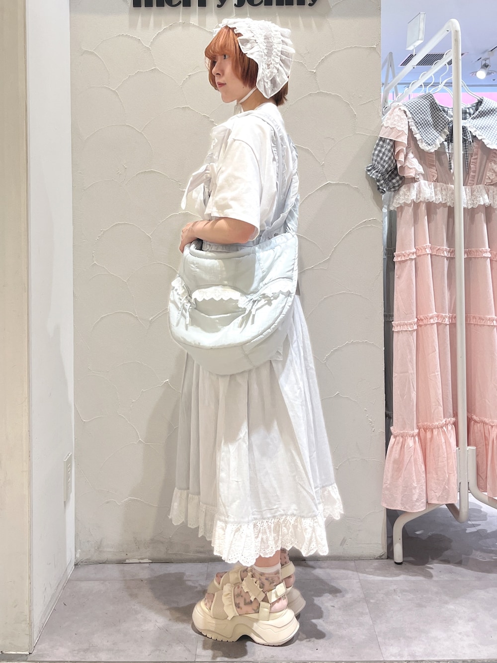 ブルー系のショルダーバッグ、ホワイト系のTシャツ/カットソー、ブルー系のジャンパースカートを着用したレディースの夏コーディネートの3枚目の写真