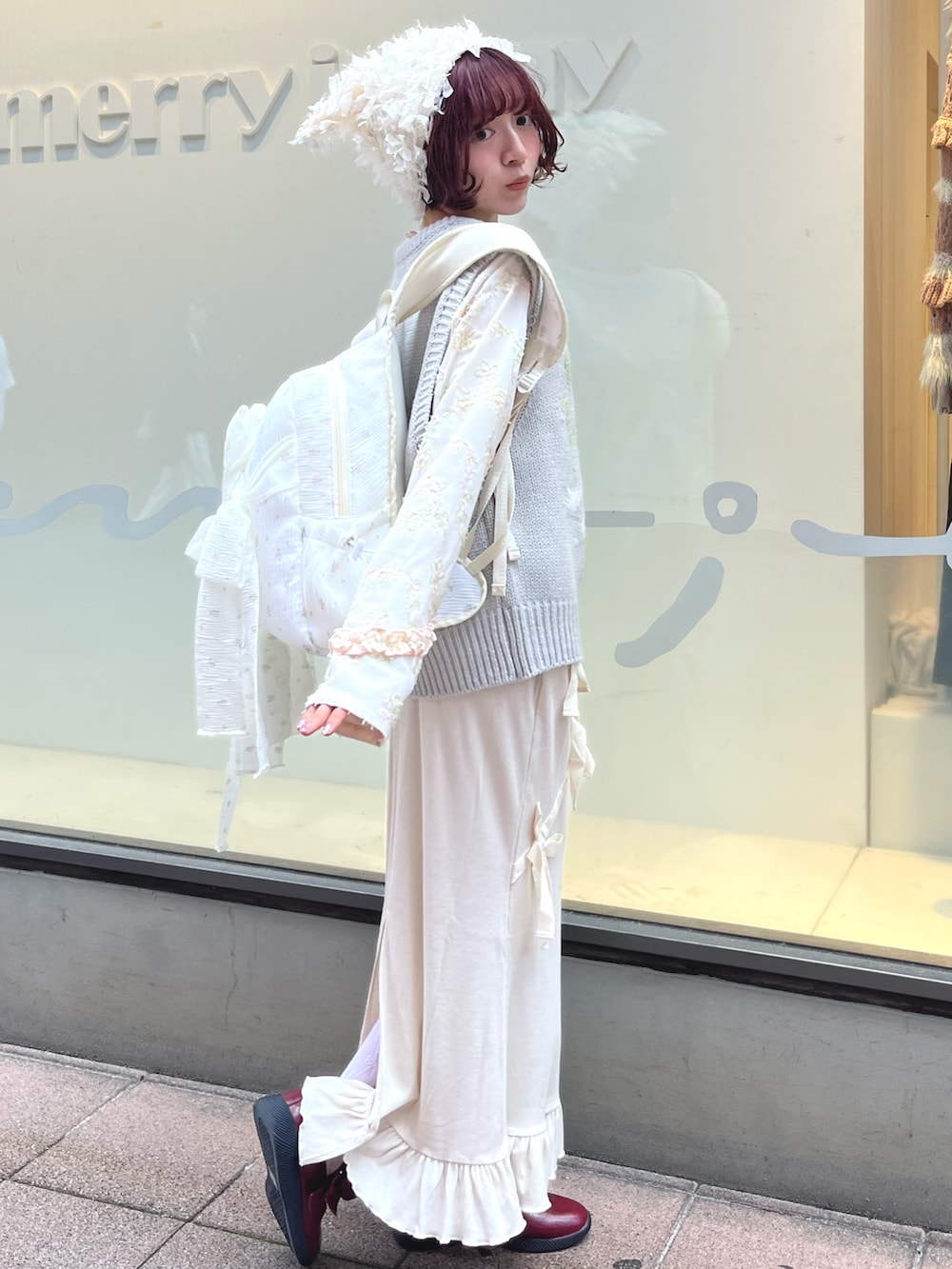 グレー系のベスト、ホワイト系のTシャツ/カットソー、ホワイト系のスカートを着用したレディースの秋コーディネートの3枚目の写真