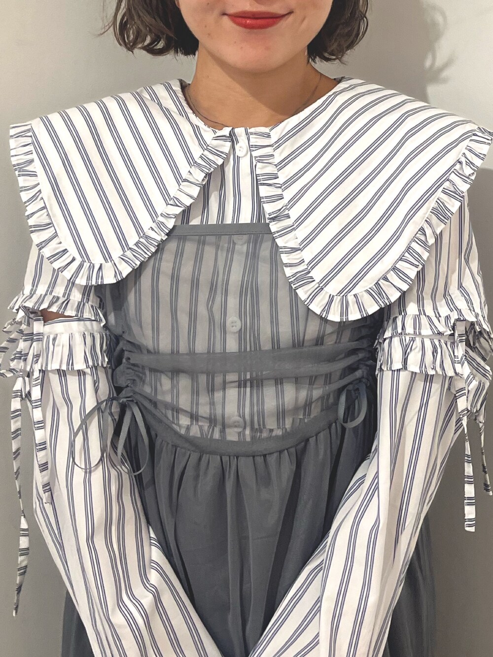 グレー系のワンピース、ホワイト系のシャツ/ブラウス、シルバー系のバレエシューズを着用したレディースの夏コーディネートの6枚目の写真