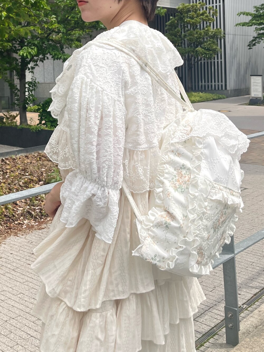 ホワイト系のスニーカー、イエロー系のバックパック/リュック、ホワイト系のカーディガン/ボレロを着用したレディースの春コーディネートの6枚目の写真