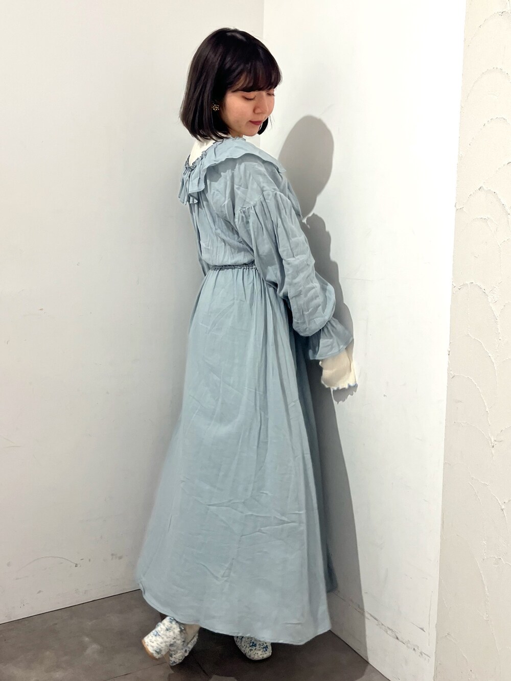 グリーン系のワンピース、ホワイト系のパンプス、ホワイト系のTシャツ/カットソーを着用したレディースの春コーディネートの3枚目の写真