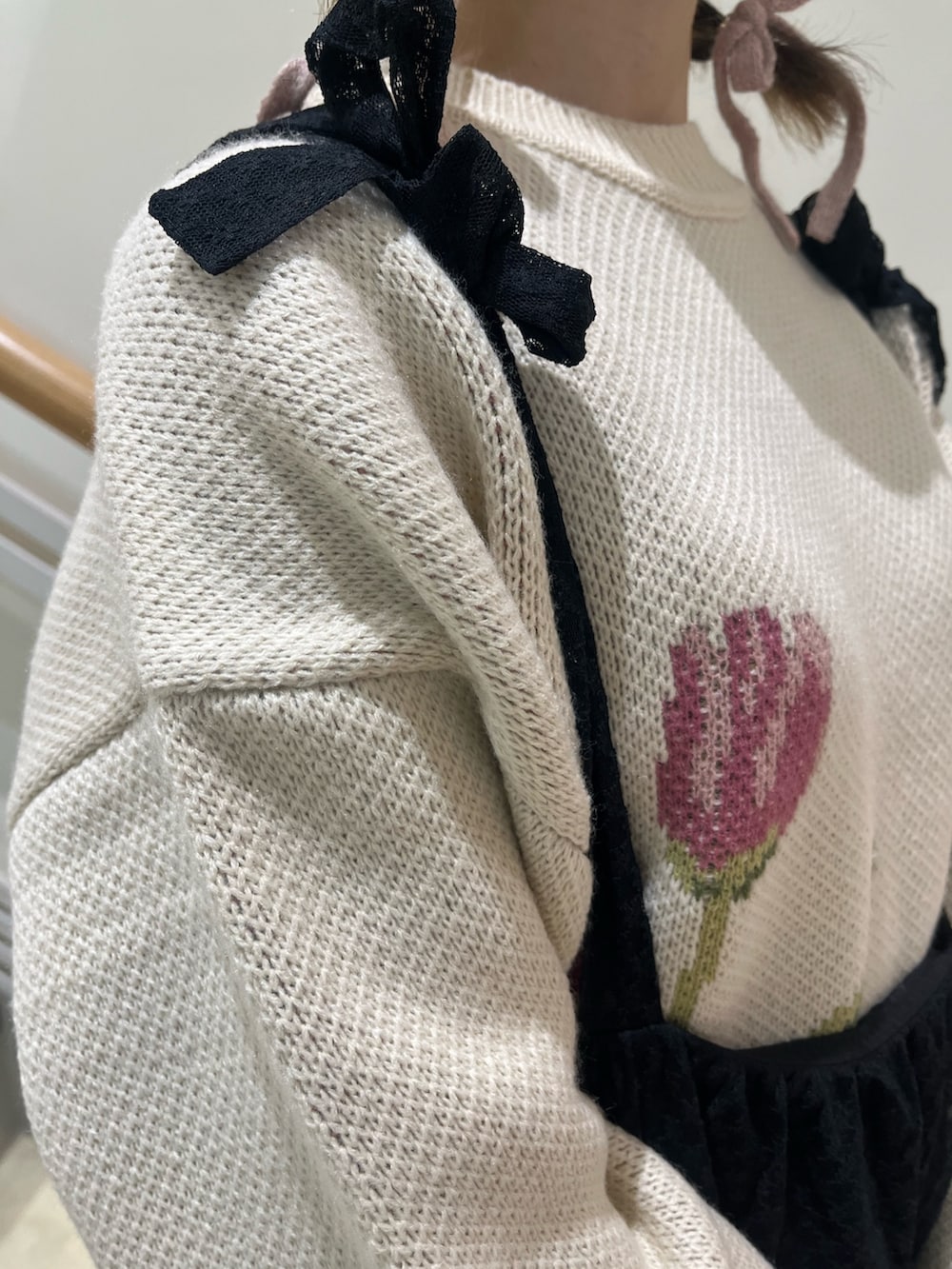 ブラック系のワンピース、ホワイト系のニット/セーター、ブラック系のパンプスを着用したレディースの冬コーディネートの8枚目の写真