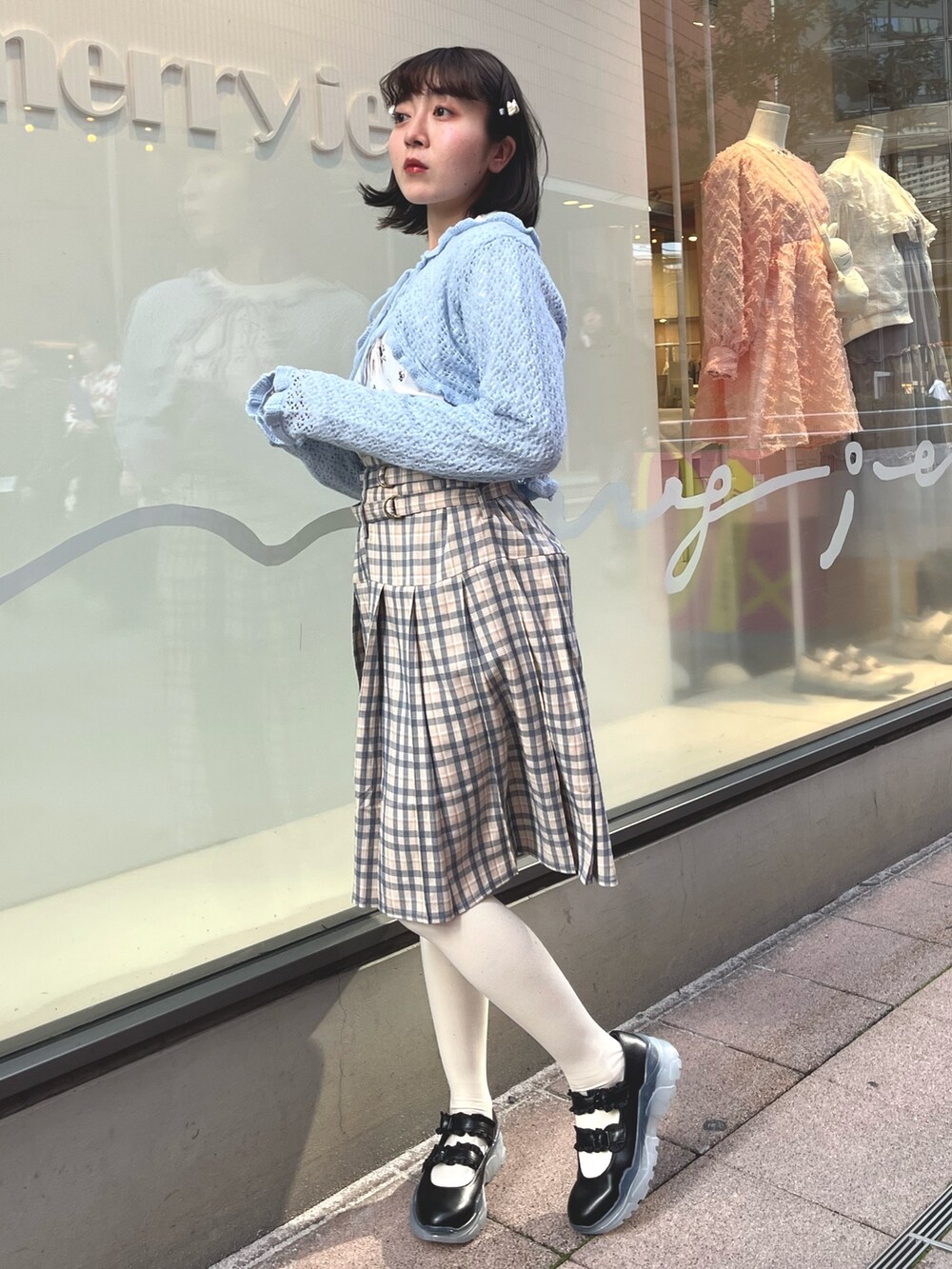 ベージュ系のスカート、ブルー系のカーディガン/ボレロ、ホワイト系のTシャツ/カットソーを着用したレディースの春コーディネートの3枚目の写真