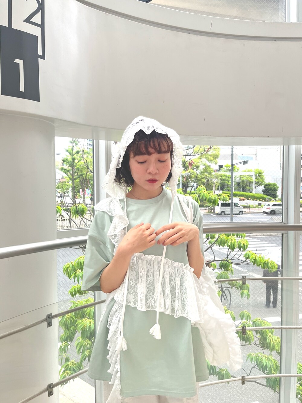 グリーン系のTシャツ/カットソー、ホワイト系のトートバッグ、ホワイト系のデニムパンツを着用したレディースの春コーディネートの6枚目の写真