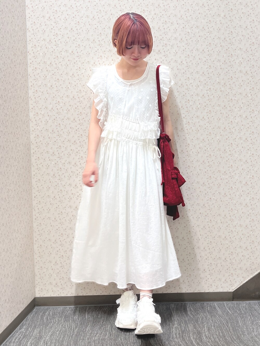 ホワイト系のワンピース、レッド系のトートバッグ、ホワイト系のスニーカーを着用したレディースの春コーディネートの2枚目の写真