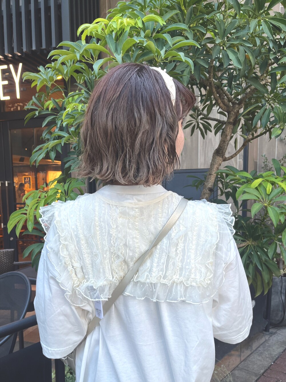 ホワイト系のTシャツ/カットソー、ゴールド系のショルダーバッグ、ブラウン系のスラックスを着用したレディースの夏コーディネートの5枚目の写真