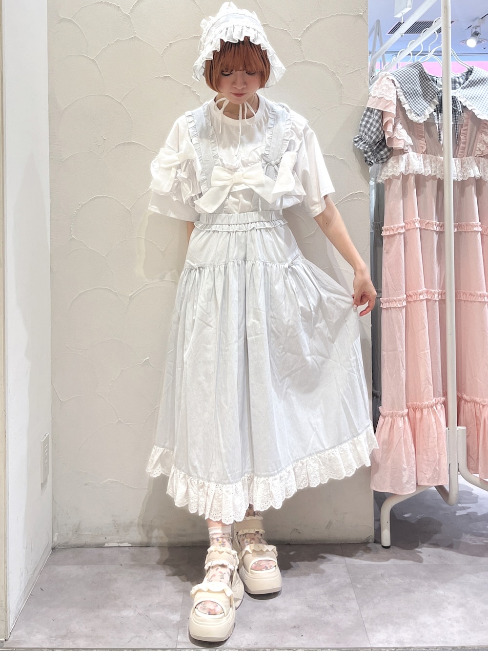 ブルー系のショルダーバッグ、ホワイト系のTシャツ/カットソー、ブルー系のジャンパースカートを着用したレディースの夏コーディネートの5枚目の写真