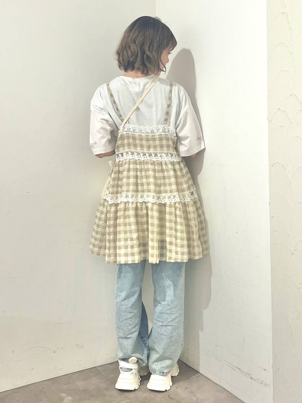 ベージュ系のキャミソール、ホワイト系のTシャツ/カットソー、ホワイト系のショルダーバッグを着用したレディースの春コーディネートの3枚目の写真