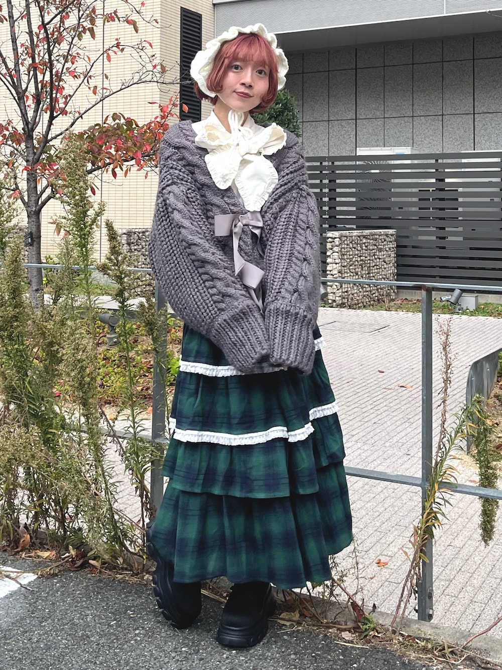 グリーン系のスカート、グレー系のカーディガン/ボレロ、ホワイト系のシャツ/ブラウスを着用したレディースの秋コーディネートの2枚目の写真