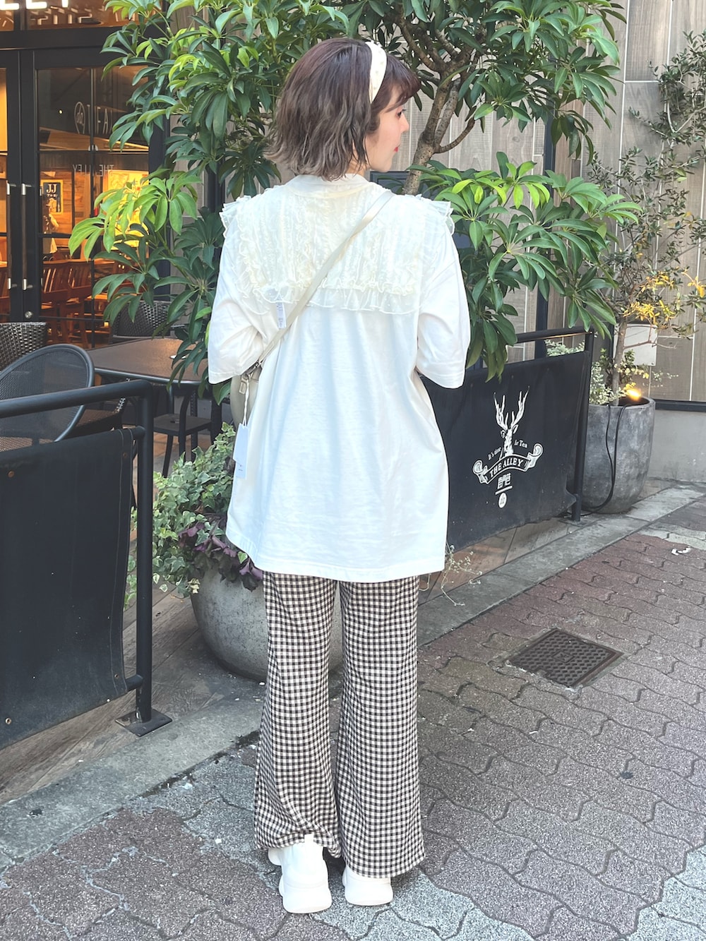 ホワイト系のTシャツ/カットソー、ゴールド系のショルダーバッグ、ブラウン系のスラックスを着用したレディースの夏コーディネートの3枚目の写真