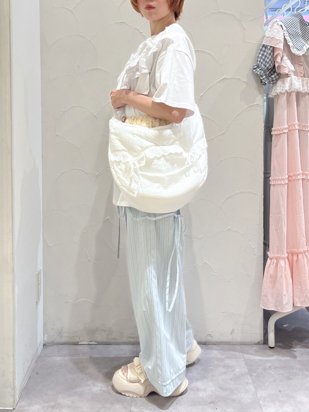 ホワイト系のショルダーバッグ、ホワイト系のTシャツ/カットソー、ブルー系のスラックスを着用したレディースの夏コーディネートの3枚目の写真