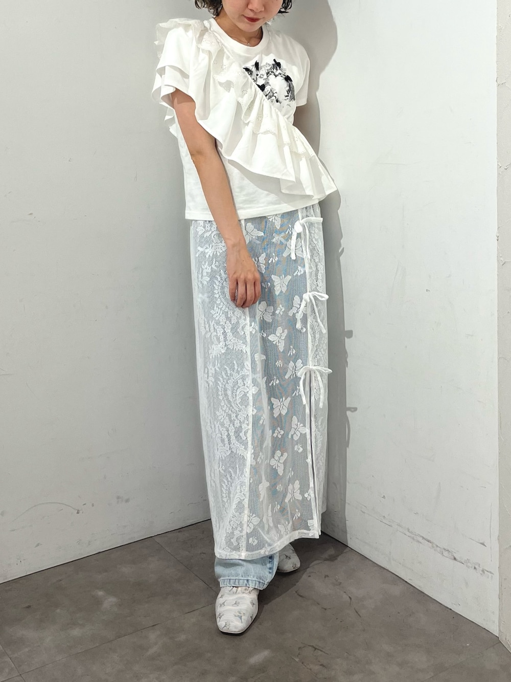 ホワイト系のスカート、ホワイト系のTシャツ/カットソー、ブルー系のデニムパンツを着用したレディースの春コーディネートの2枚目の写真